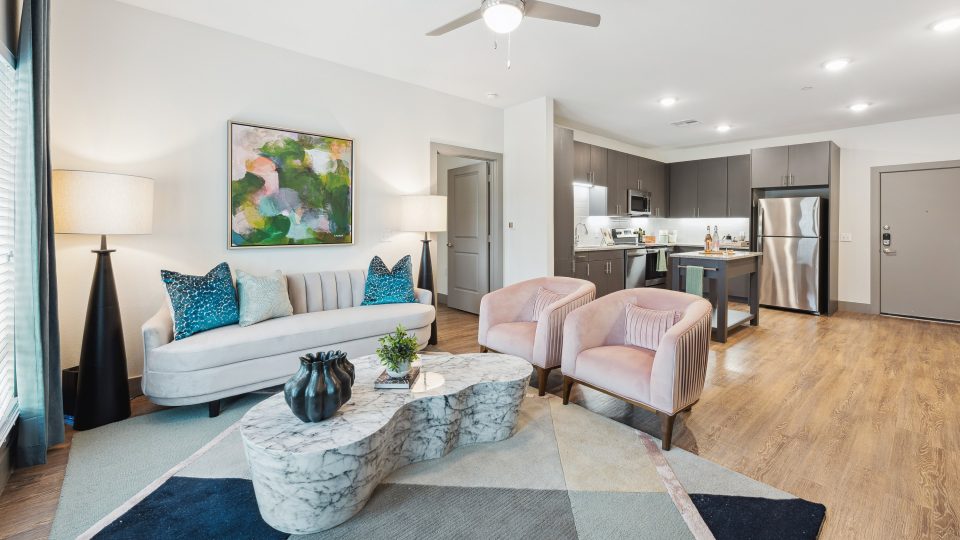 a living room with a couch, coffee table and chairs at The BroadVue